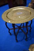 An Eastern style brass topped folding table