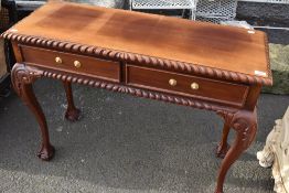 A reproduction hardwood console table