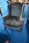 An early 20th Century wingback easy chair with ball and claw feet