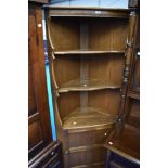 A modern mid stained Ercol corner shelf with cupboard to lower part