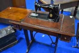 A traditional treadle sewing machine in wooden table