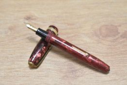 A Conway Stewart 84 lever fill fountain pen in red marble with single band to cap (wrong cap) having