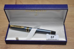 A boxed Waterman Expert cartridge converter fountain pen in grey with gold trim having a Watermans