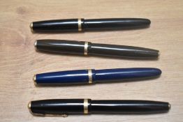 Four Parker Duofold three button fill fountain pens in olive green black and an aero fill blue all