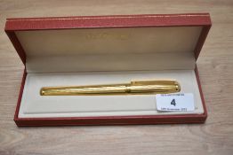 A boxed S T Dupont Fidelio gold plated cartridge fountain pen having 14k Dupont nib