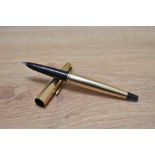 A Parker 45 Insignia aero fill fountain pen in gold fill with black tassie