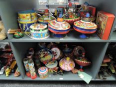 Two shelves of vintage tin plate Spinning Tops, Drums, Music Boxes and Kaleidoscopes etc, Chad