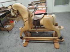 A House of Marbles Wooden Rocking Horse having real horse hair mane and tail, leather saddle on