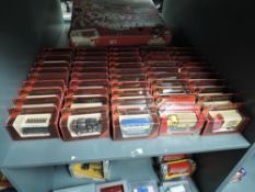 A shelf of 1980's Matchbox Models of Yesteryear die-casts, Vans and Buses, all in red window display