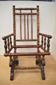 A Victorian mahogany Dolls or Childs small Rocking Chair, having turned frame and spindles, sprung