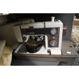 A vintage Singer electric sewing machine with instructions.