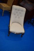 A Victorian mahogany frame nursing chair having later upholstery