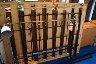 A Victorian metal double bed having painted frame and brass detailing, with later wooden slatted