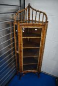 An oriental bamboo corner display having laquerwork detailing . Dimensions approx H156 W57 D40cm