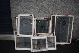A selection of vintage windows in frame, with stained glass panels