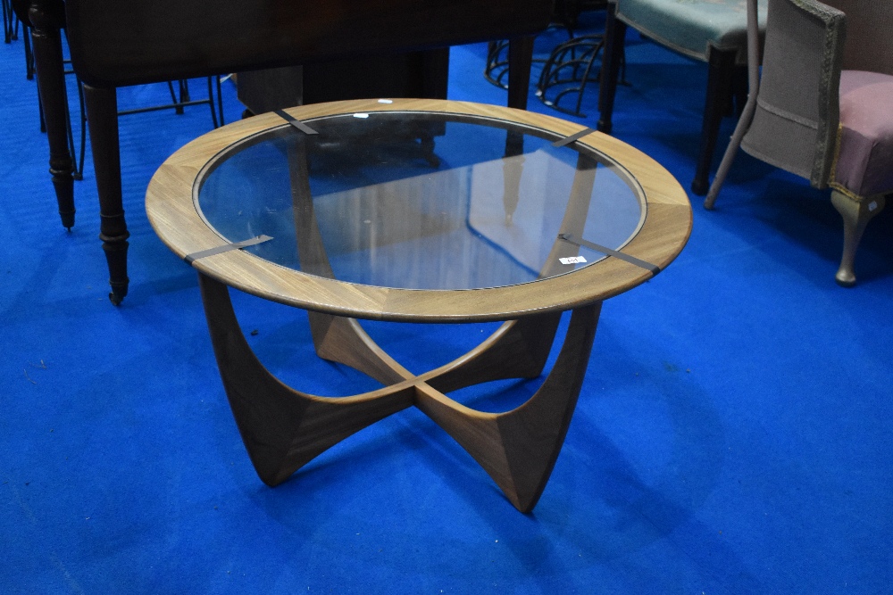A vintage G plan coffee table having teak frame with glass centre, diameter approx. 84cm, labelled