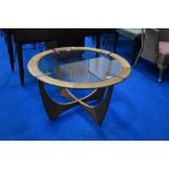 A vintage G plan coffee table having teak frame with glass centre, diameter approx. 84cm, labelled