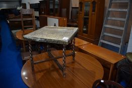 A vintage brass top table having oak twist folding frame , approx 54 x 54cm