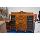 A vintage side by side display cabinet with marquetry decoration to front panel, width approx 140cm,