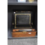 A Victorian walnut writing slope, having a shaped vacant cartouche and metal banding to the top, and