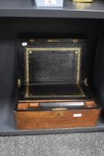 A Victorian walnut writing slope, having a shaped vacant cartouche and metal banding to the top, and