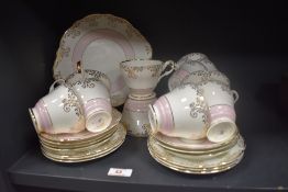 A mid-century Regency bone china tea set, decorated in bands of pink with a gilt pattern