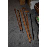 A collection of walking sticks, to include one with white metal handle and ebonised shaft and