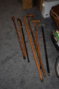 A collection of walking sticks, to include one with white metal handle and ebonised shaft and