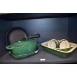 A Le Creuset green enamelled and lidded casserole dish, a griddle pan to match, two AGA frying pans,