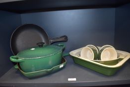 A Le Creuset green enamelled and lidded casserole dish, a griddle pan to match, two AGA frying pans,