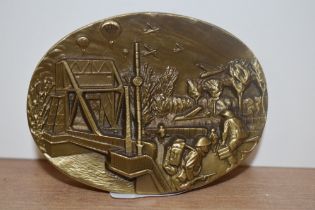 A solid brass commemorative WW2 paperweight, relief moulded to the top with a D-Day scene, inscribed