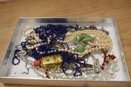 A small collection of costume jewellery, including synthetic pearls, a faceted glass necklace, and a