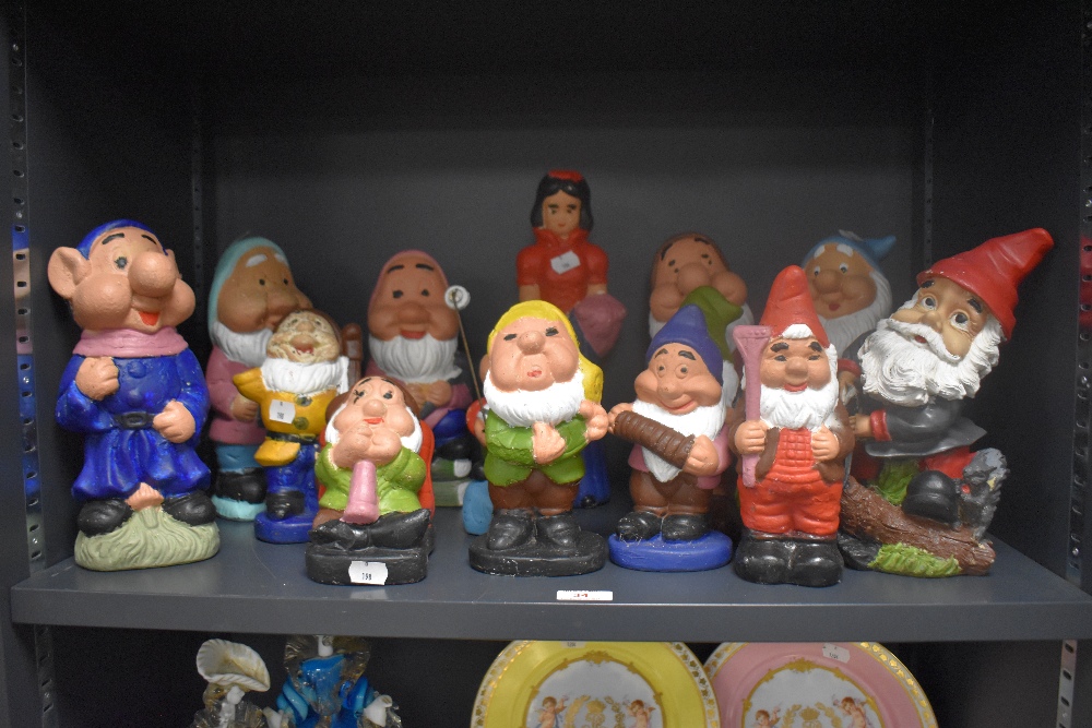 An assorted collection of vintage garden gnomes, including Snow White and the Seven Dwarves