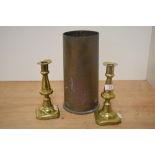 A pair of 19th Century brass candlesticks, measuring 20cm tall, and a brass artillery shell case