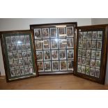 Two framed, glazed and mounted sets of Players cigarette cards, and a similar framed set of cards.