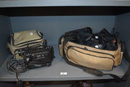 A Canon 8mm video camcorder with bag, and an Olympus OM10 camera, with bag of lenses