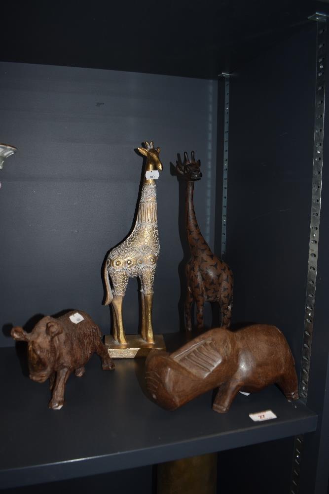 An African tribal art style hippo ornament, a carved wood rhinoceros, and two ornamental giraffe