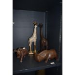 An African tribal art style hippo ornament, a carved wood rhinoceros, and two ornamental giraffe