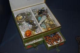 A box of assorted costume jewellery, including white metal brooches, synthetic pearls, and beaded