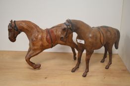 Two Liberty style leather clad horse statues, the largest measures 40cm long