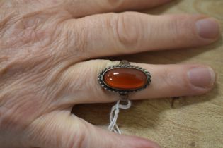 A ladies Carnelian style ring with white metal band
