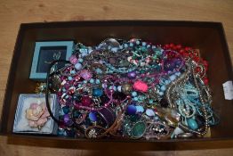 An assorted collection of costume jewellery, brooches, and bead necklaces