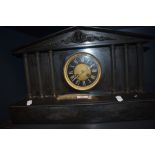 A Victorian black slate mantel clock, of Architectural form, with enamelled Roman dial, two train