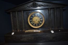 A Victorian black slate mantel clock, of Architectural form, with enamelled Roman dial, two train