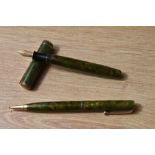 A Parker Moderne Duette Jr button fill fountain pen and propelling pencil set in green and gold