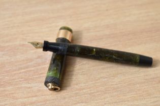 A Parker Lady Duofold Lucky Curve button fill fountain pen in mottled green with broad band to a