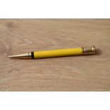 A Parker Duofold propelling pencil in manderin yellow, slight damage to gold top and light crack