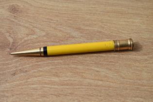 A Parker Duofold propelling pencil in manderin yellow, slight damage to gold top and light crack