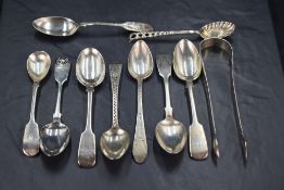 A group of mixed silver spoons and sugar tongs, George III and later, three with well executed