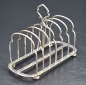 An Edwardian silver six division toast rack, the divisions of arched form with central carrying